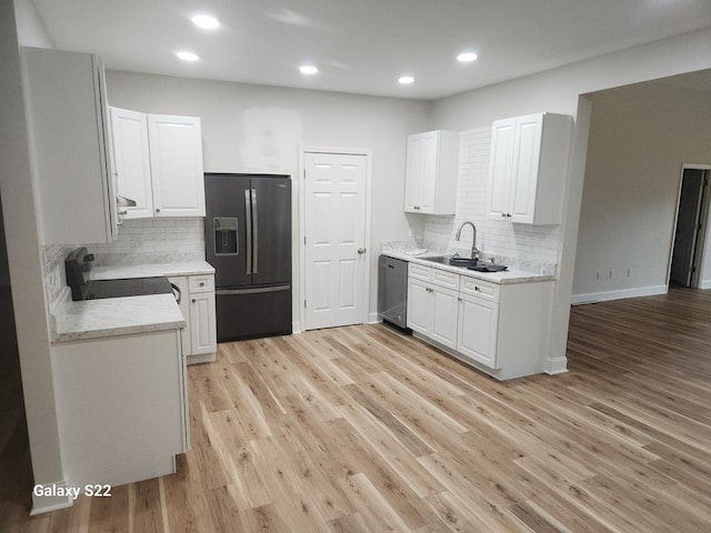 kitchen with black refrigerator with ice dispenser, dishwasher, white cabinetry, stove, and sink