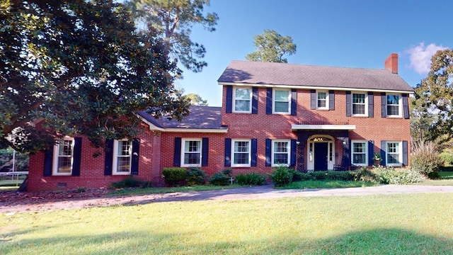 colonial-style house featuring a front lawn