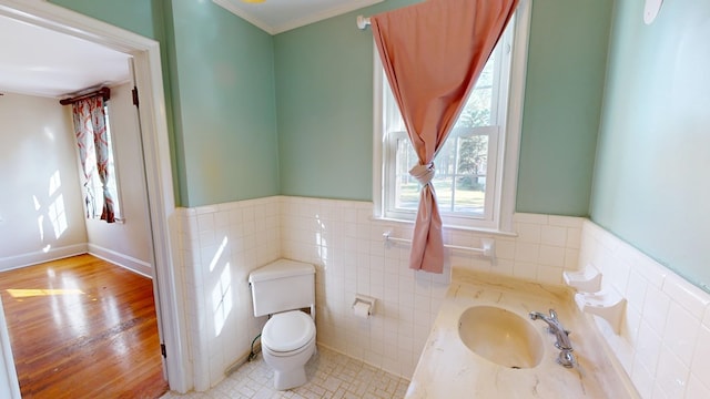 bathroom featuring tile patterned floors, tile walls, sink, toilet, and ornamental molding