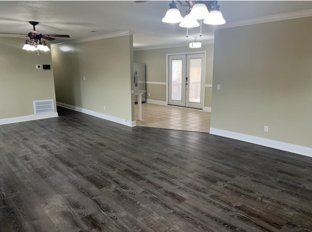 unfurnished living room featuring baseboards, visible vents, dark wood-style floors, crown molding, and french doors