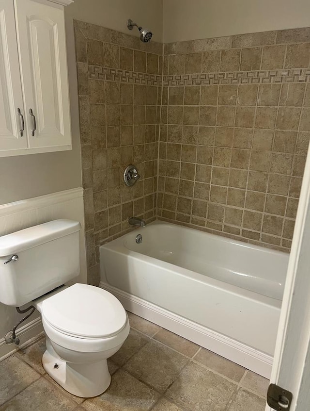 full bath featuring a wainscoted wall, shower / tub combination, and toilet