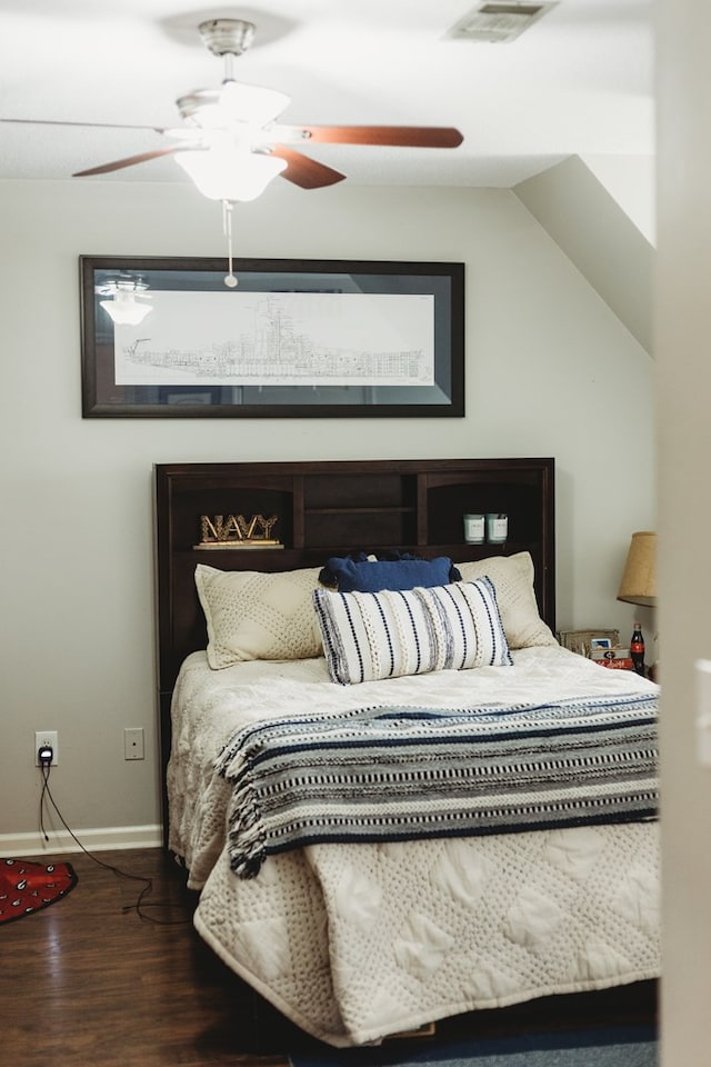 bedroom with dark wood-type flooring, vaulted ceiling, and ceiling fan