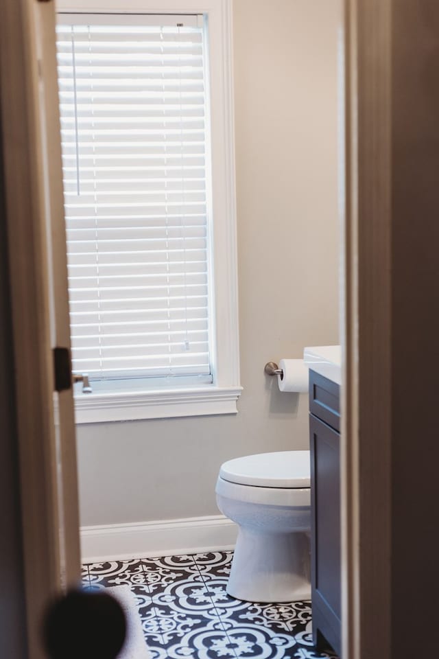 bathroom with toilet, tile patterned floors, and vanity