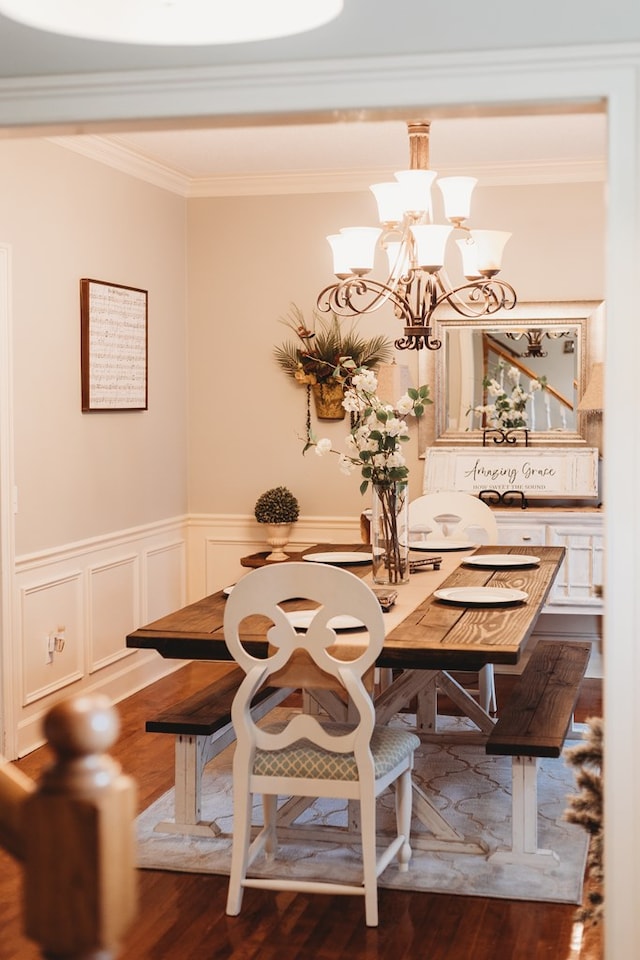 unfurnished dining area with dark hardwood / wood-style floors, ornamental molding, and a notable chandelier