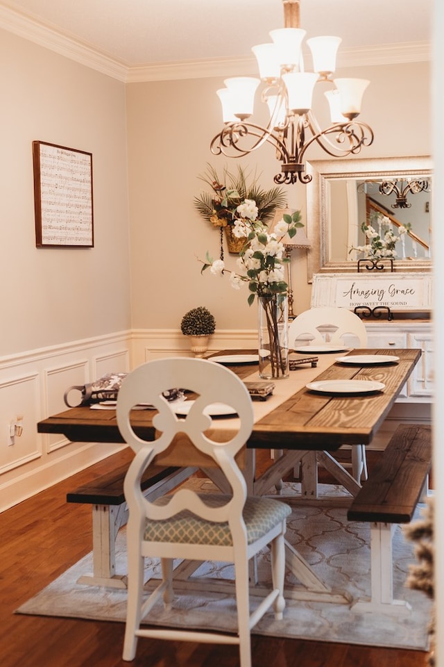 unfurnished dining area featuring a chandelier, crown molding, and hardwood / wood-style floors