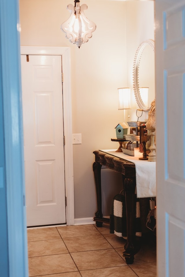 hallway with a chandelier and tile patterned flooring