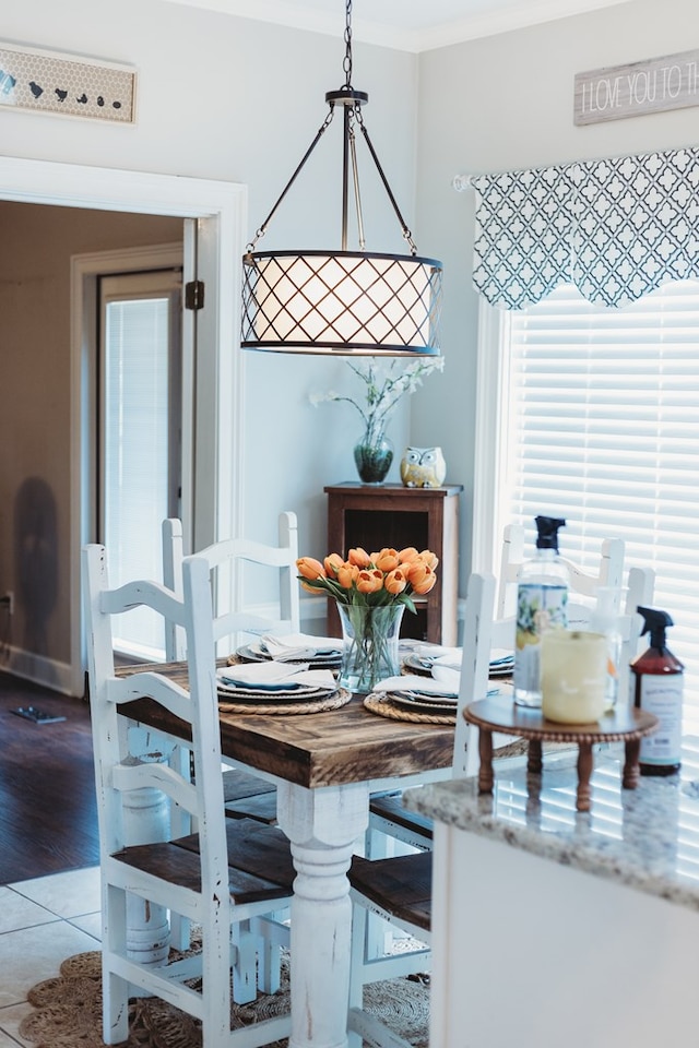 dining room with crown molding and light tile patterned flooring