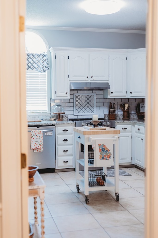 kitchen featuring white cabinets, decorative backsplash, stainless steel dishwasher, and light tile patterned flooring