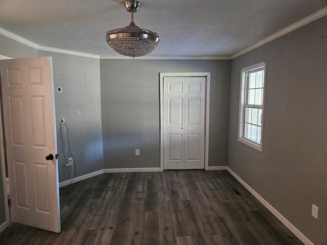 unfurnished bedroom featuring crown molding, dark wood finished floors, a closet, a textured ceiling, and baseboards