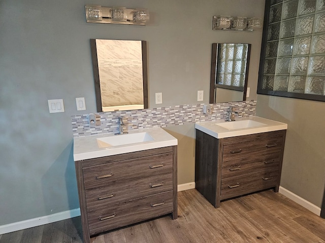 bathroom featuring backsplash, two vanities, and a sink