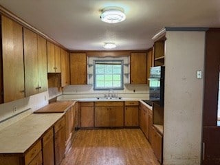 113 Sharon Cir, Americus, GA 31709 - kitchen with oven, brown cabinetry, wood finished floors, a sink, and light countertops