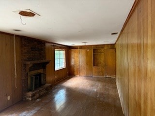 113 Sharon Cir, Americus, GA 31709 - unfurnished living room with wooden walls, a fireplace, and wood finished floors