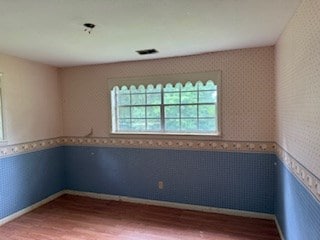 113 Sharon Cir, Americus, GA 31709 - unfurnished room featuring wood finished floors, a wainscoted wall, wallpapered walls, and baseboards