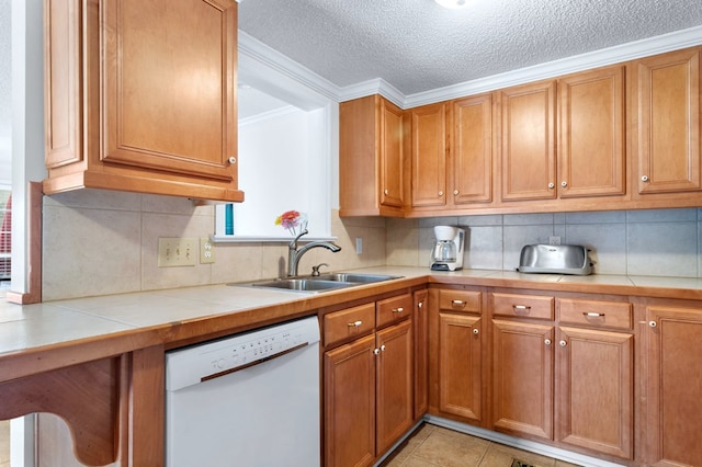 kitchen with white dishwasher, a sink, tile counters, and brown cabinets