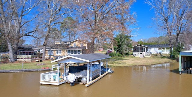 view of dock featuring a yard, a water view, and boat lift