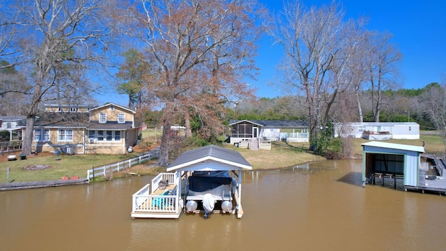 dock area featuring a lawn, a water view, boat lift, and fence