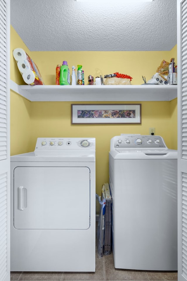 laundry room featuring laundry area, a textured ceiling, and washing machine and clothes dryer