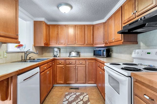 kitchen featuring brown cabinets, tile counters, a sink, white appliances, and under cabinet range hood