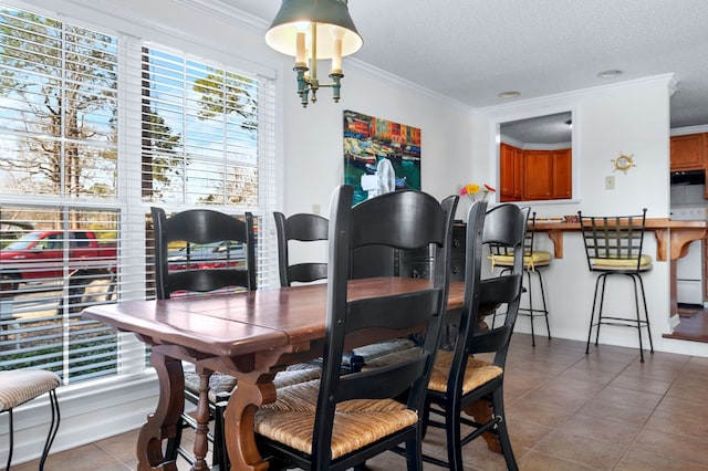 tiled dining room with a textured ceiling and ornamental molding