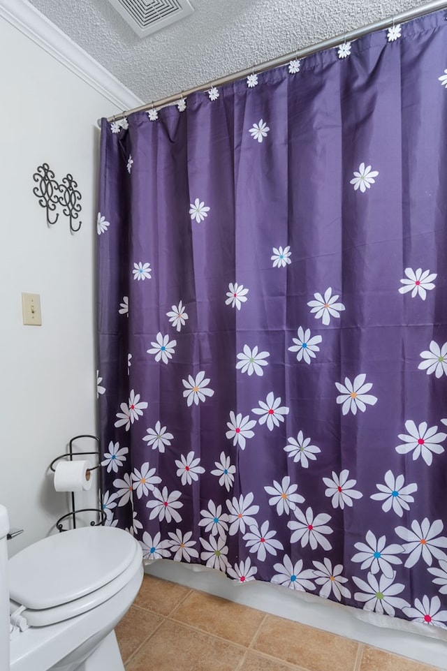 bathroom featuring a textured ceiling, tile patterned flooring, toilet, visible vents, and crown molding