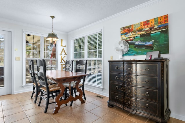 tiled dining space featuring a textured ceiling, ornamental molding, a wealth of natural light, and baseboards