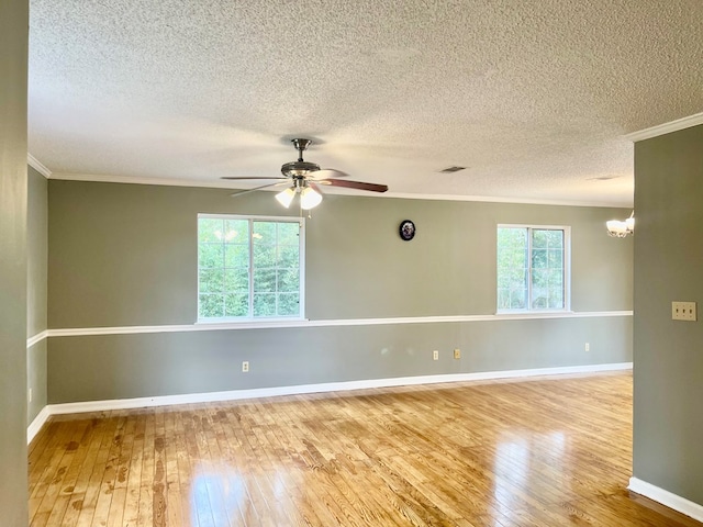 empty room with crown molding, hardwood / wood-style floors, and ceiling fan with notable chandelier