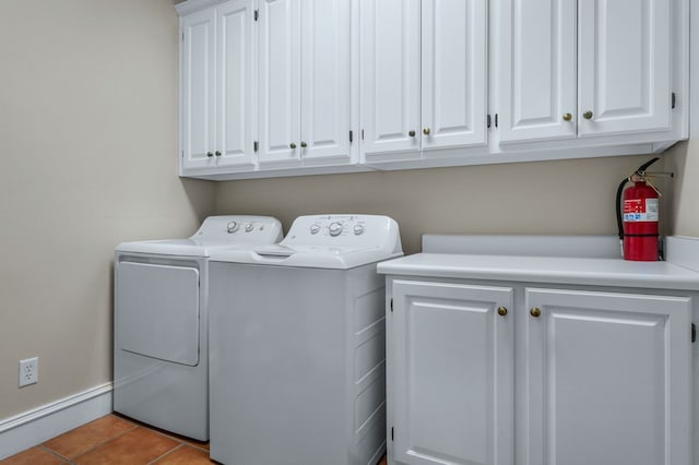 washroom with washer and clothes dryer, cabinets, and light tile patterned flooring