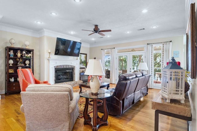 living room featuring ceiling fan, light hardwood / wood-style flooring, ornamental molding, and french doors