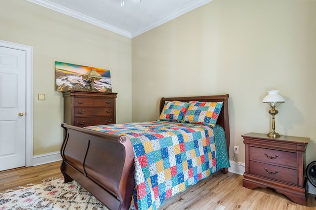 bedroom with ornamental molding and light hardwood / wood-style flooring