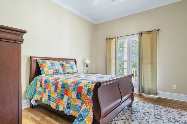 bedroom featuring light wood-type flooring, ceiling fan, and ornamental molding