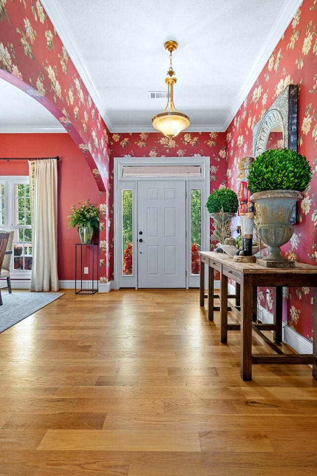 foyer entrance with hardwood / wood-style floors and crown molding