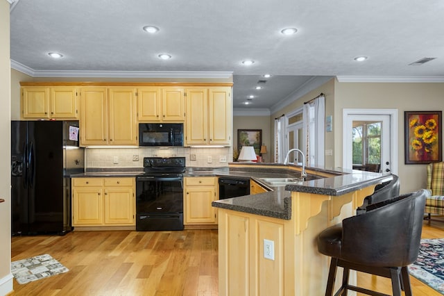 kitchen featuring black appliances, light brown cabinetry, light wood-type flooring, sink, and ornamental molding