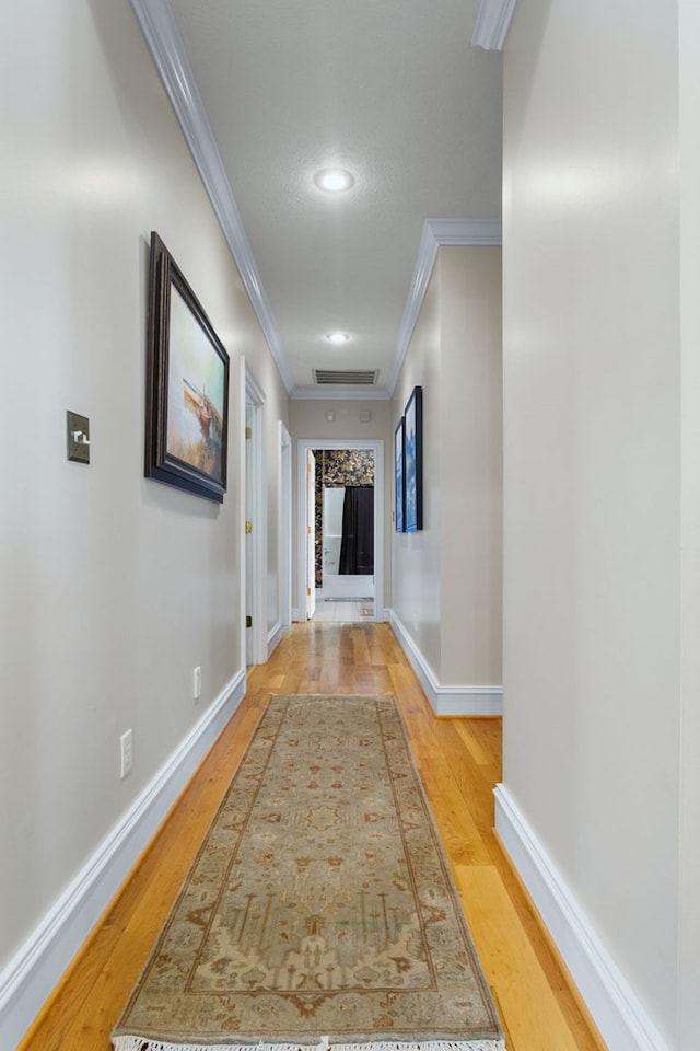 corridor featuring hardwood / wood-style floors and crown molding