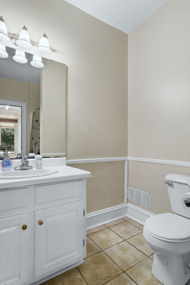 bathroom with vanity, toilet, an inviting chandelier, and tile patterned flooring