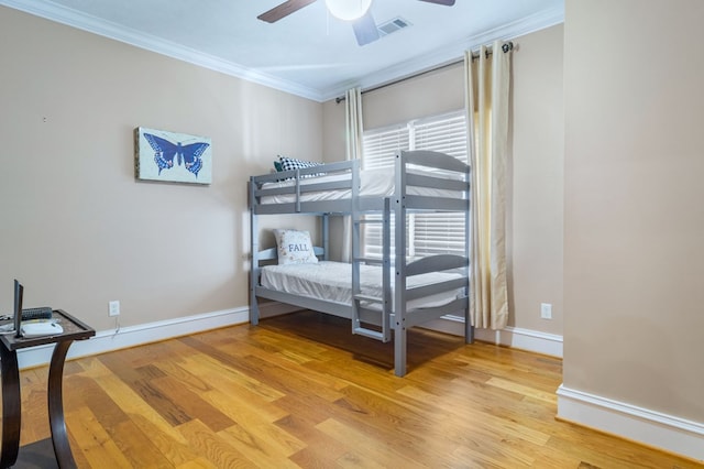 bedroom featuring ceiling fan, light hardwood / wood-style flooring, and ornamental molding