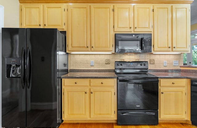 kitchen featuring light brown cabinetry, decorative backsplash, and black appliances