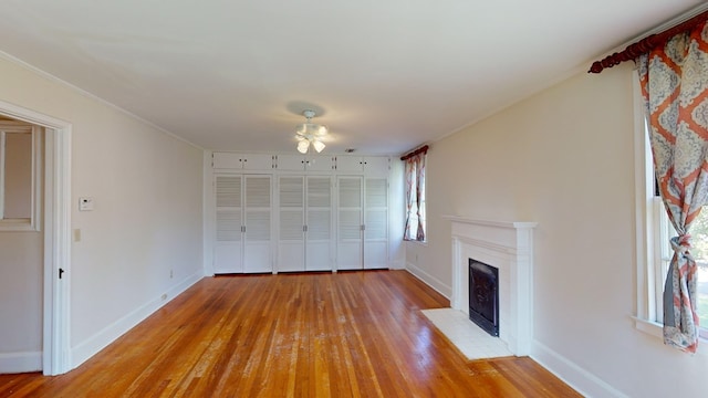 815 E 19th Ave, Cordele, GA 31015 - unfurnished living room featuring a fireplace with flush hearth, light wood finished floors, baseboards, ceiling fan, and ornamental molding