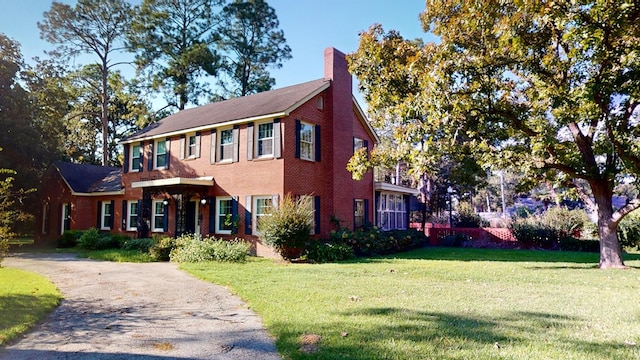 815 E 19th Ave, Cordele, GA 31015 - colonial inspired home featuring a front yard, a chimney, and brick siding