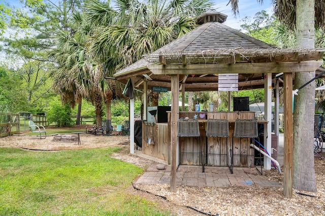 view of yard with fence, a fire pit, a gazebo, and outdoor dry bar