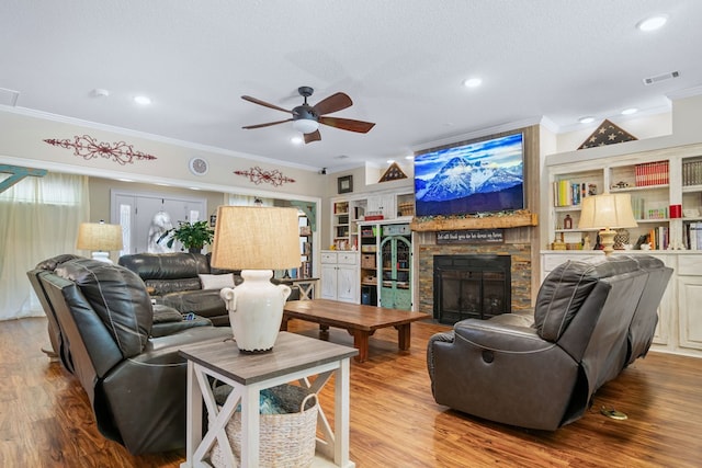 living area with ceiling fan, ornamental molding, wood finished floors, and visible vents