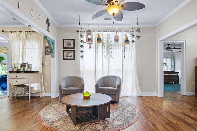 living area with wood finished floors, visible vents, baseboards, and ceiling fan
