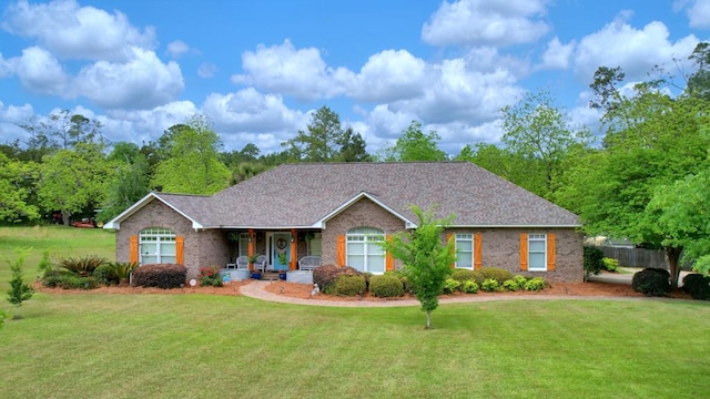 view of front of property with brick siding, a porch, and a front yard