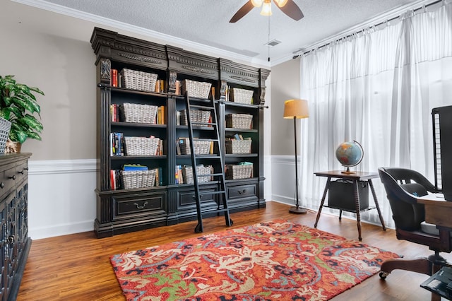 office area featuring ceiling fan, crown molding, wood finished floors, and a textured ceiling