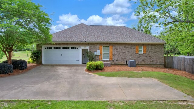 exterior space featuring roof with shingles, fence, a garage, brick siding, and aphalt driveway
