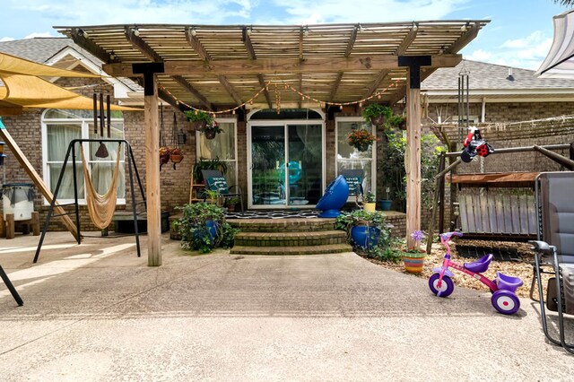 exterior space with brick siding, a pergola, and a shingled roof