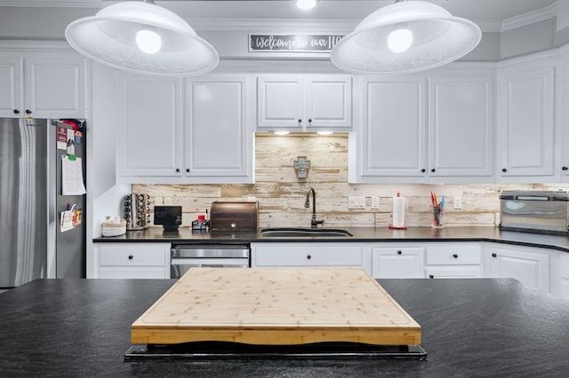 kitchen with white cabinets, dark countertops, decorative backsplash, and a sink