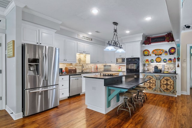 kitchen featuring dark countertops, ornamental molding, stainless steel appliances, and a sink