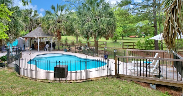 pool with a gazebo, a yard, a wooden deck, and fence