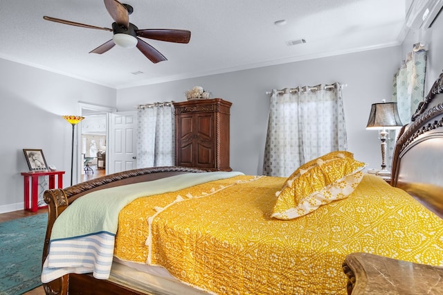 bedroom with wood finished floors, visible vents, ornamental molding, baseboards, and ceiling fan