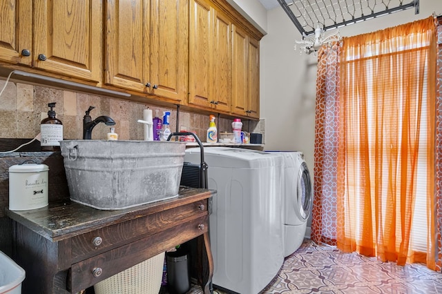 laundry area featuring light tile patterned flooring, washer and dryer, and cabinet space